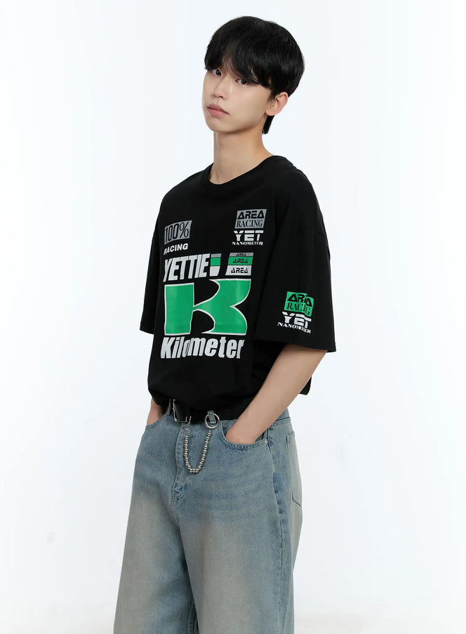 LEWKIN Men's Hip Chain Accessory IG501 in silver, side-angle worn shot clipped to belt loop, ball-bead chain with D-ring clasp, styled with black graphic tee and light blue wide-leg jeans.