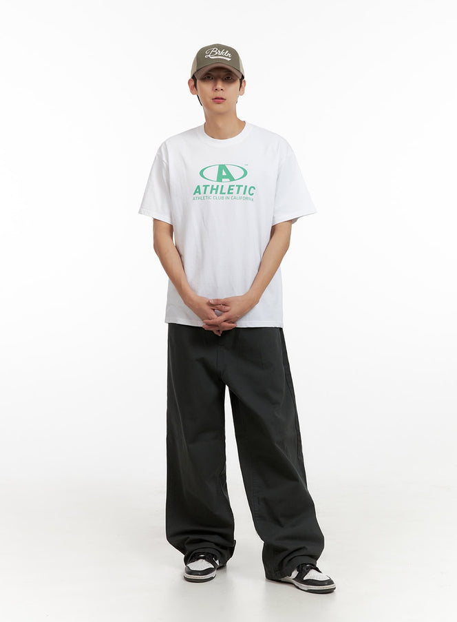 LEWKIN Men's Solid Cotton Baggy Pants IL404 in dark gray, full-length front view on model, wide-leg baggy silhouette in cotton twill, styled with white graphic tee and sneakers.