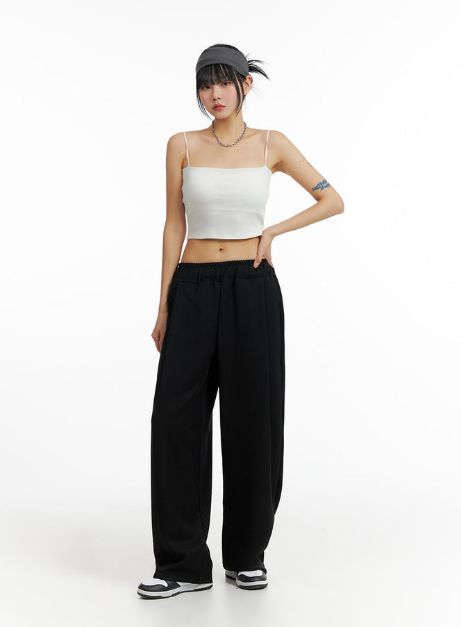 LEWKIN Solid Elastic Waist Trousers IF402 in black, front full-body on model, wide-fit petite length with banded elastic waist, center crease, paired with white crop top and sneakers.