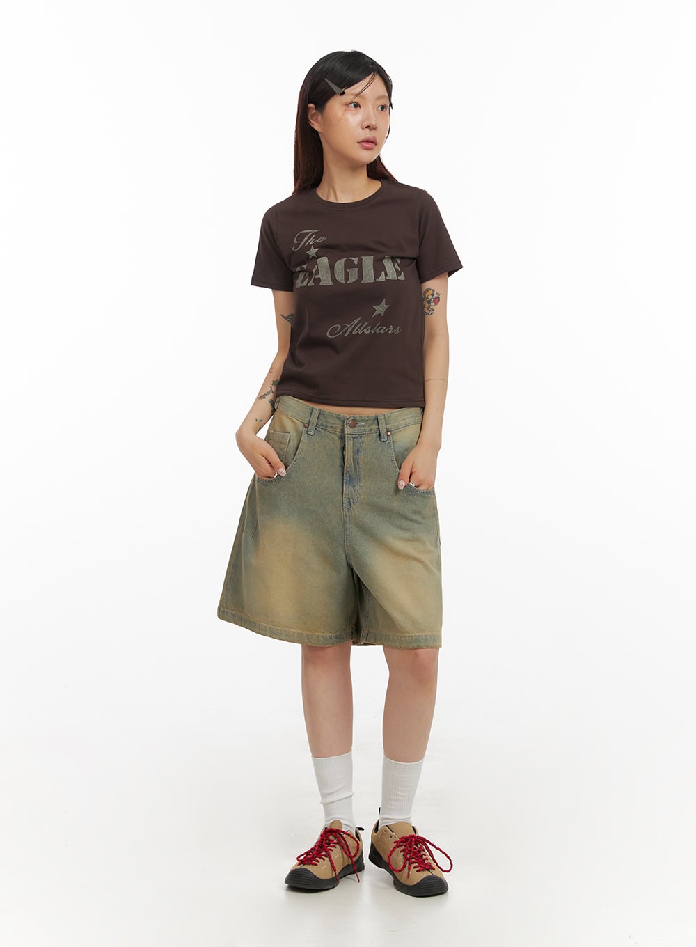 LEWKIN Vintage Washed Baggy Jorts IY410 in light blue, full-length front view on model, wide-fit washed denim shorts with vintage sun-faded finish, styled with a brown graphic crop tee and trail sneakers.