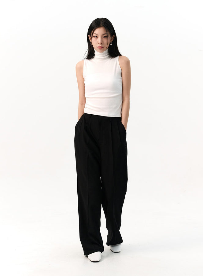 LEWKIN Wide-Fit Pintuck Trousers IO320 in black, full-length front view on model, wide-leg silhouette with pintuck pleats, paired with white sleeveless turtleneck and white loafers.