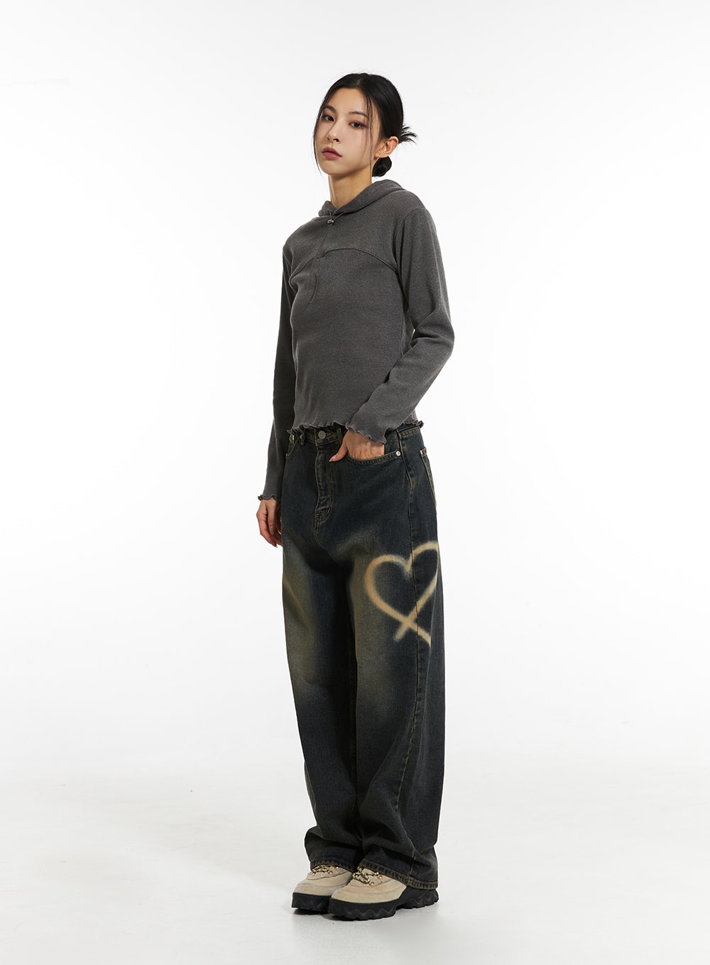 LEWKIN Heart-Bleached Wide Leg Jeans IN308 in dark blue, 3/4 front view on model, washed denim with spray-painted heart graphic on thigh, wide fit, paired with grey cropped hoodie and chunky sneakers.