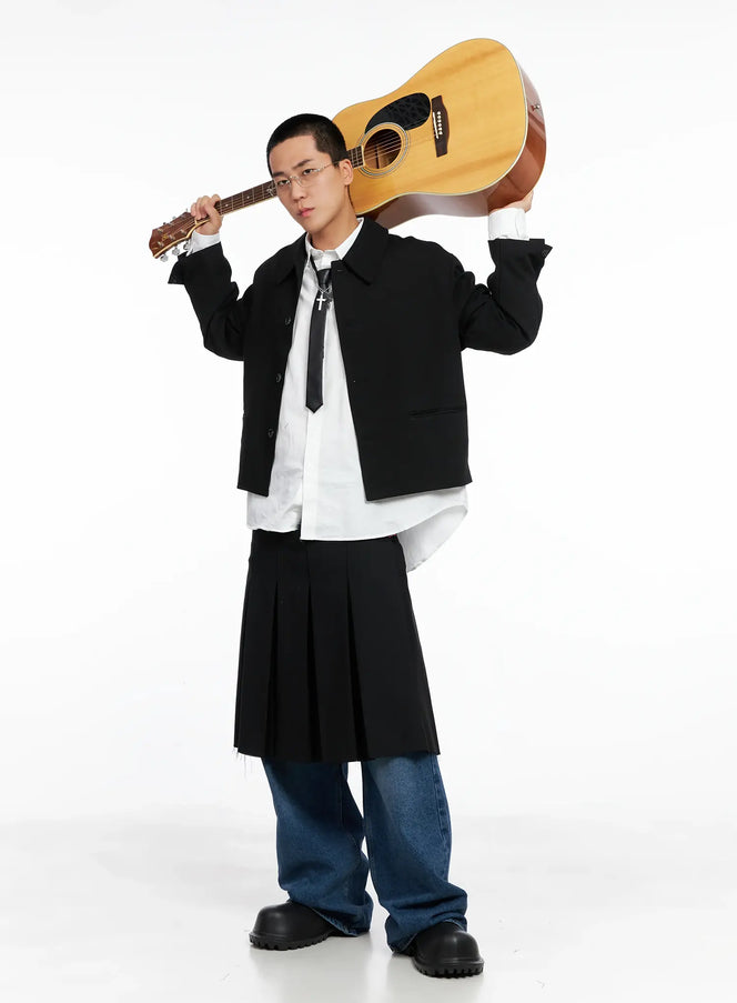 LEWKIN Men's Cropped Button-Up Jacket IS502 in black, editorial full-body on model holding guitar overhead, layered over white shirt with black tie and pleated midi skirt over wide-leg jeans.