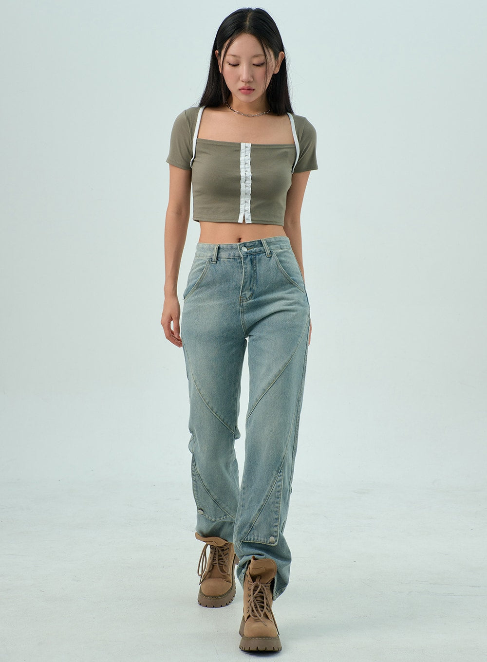 LEWKIN Straight Leg Jeans CY330 in light blue wash, full-length front walking shot on model, straight-fit cotton denim with geometric panel seams, paired with olive crop top and tan boots.