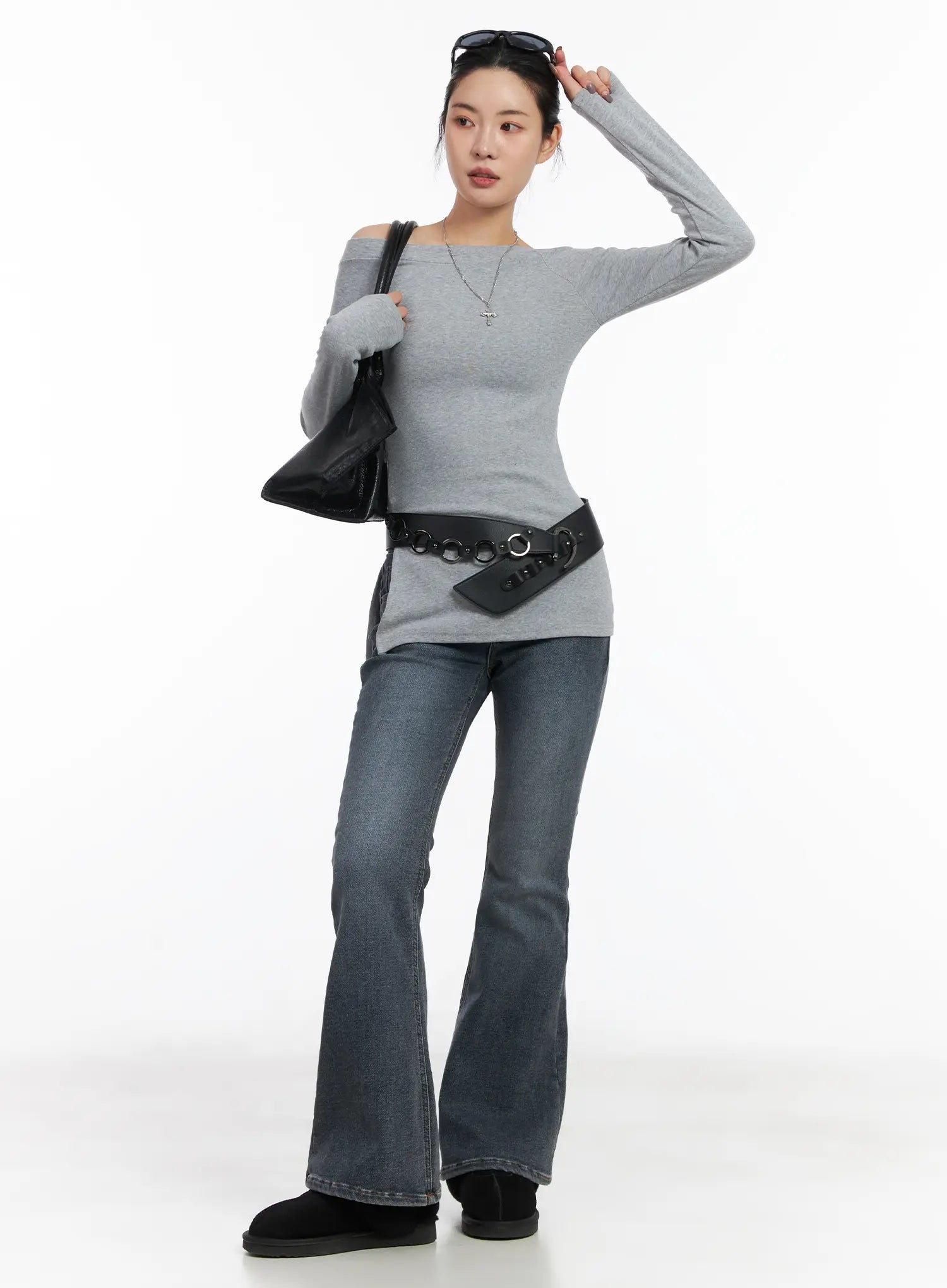 LEWKIN Kiera Low-Rise Fleece-Lined Bootcut Jeans CD509 in washed dark blue, full-body front on model, flared hem, paired with grey off-shoulder top, grommet belt, and black shearling boots.