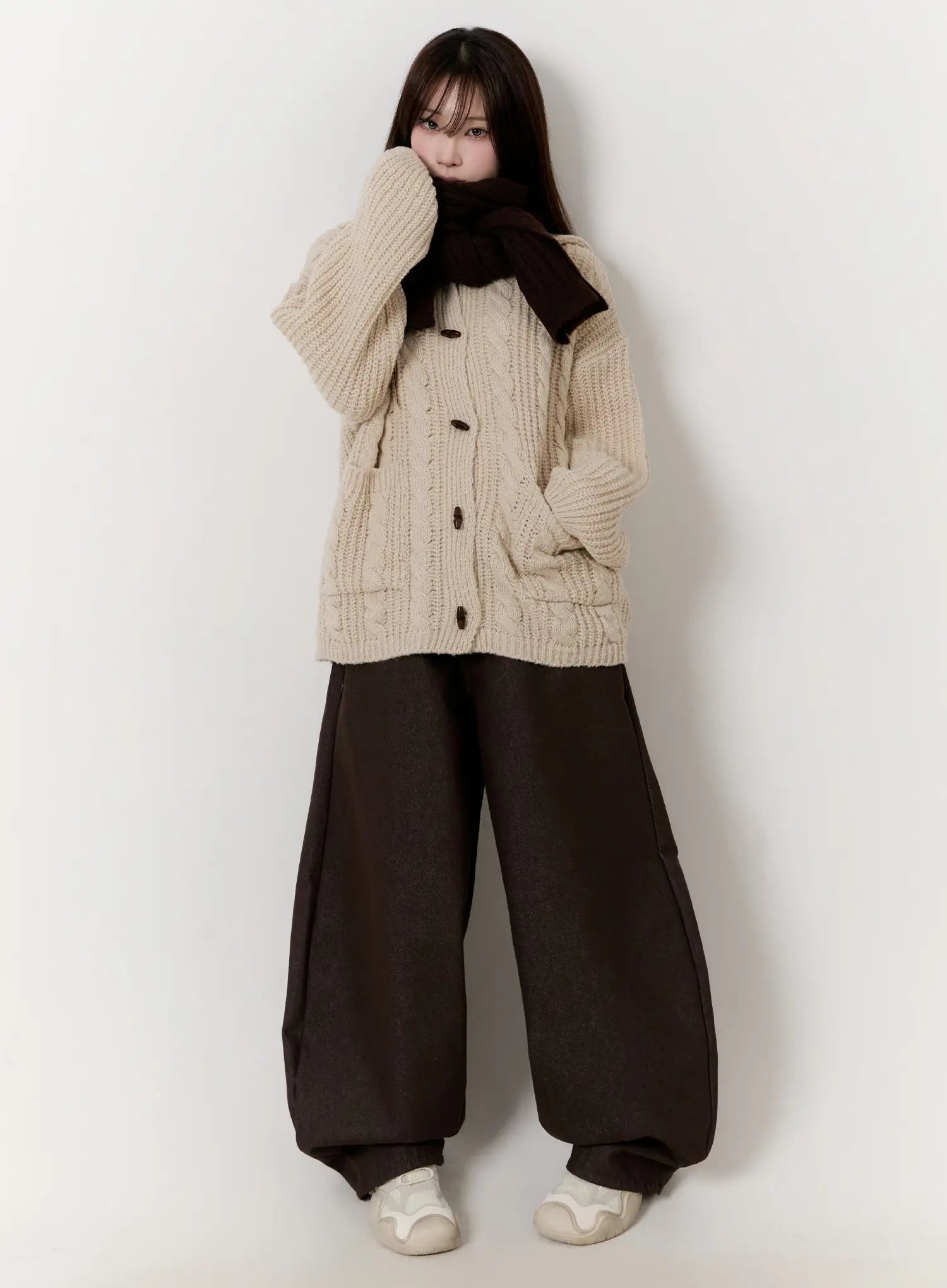 LEWKIN Emely Wide Leg Jeans CN524 in dark brown, full front view on model, voluminous wide-leg silhouette pooling at ankles, styled with cream cable-knit cardigan and dark scarf.
