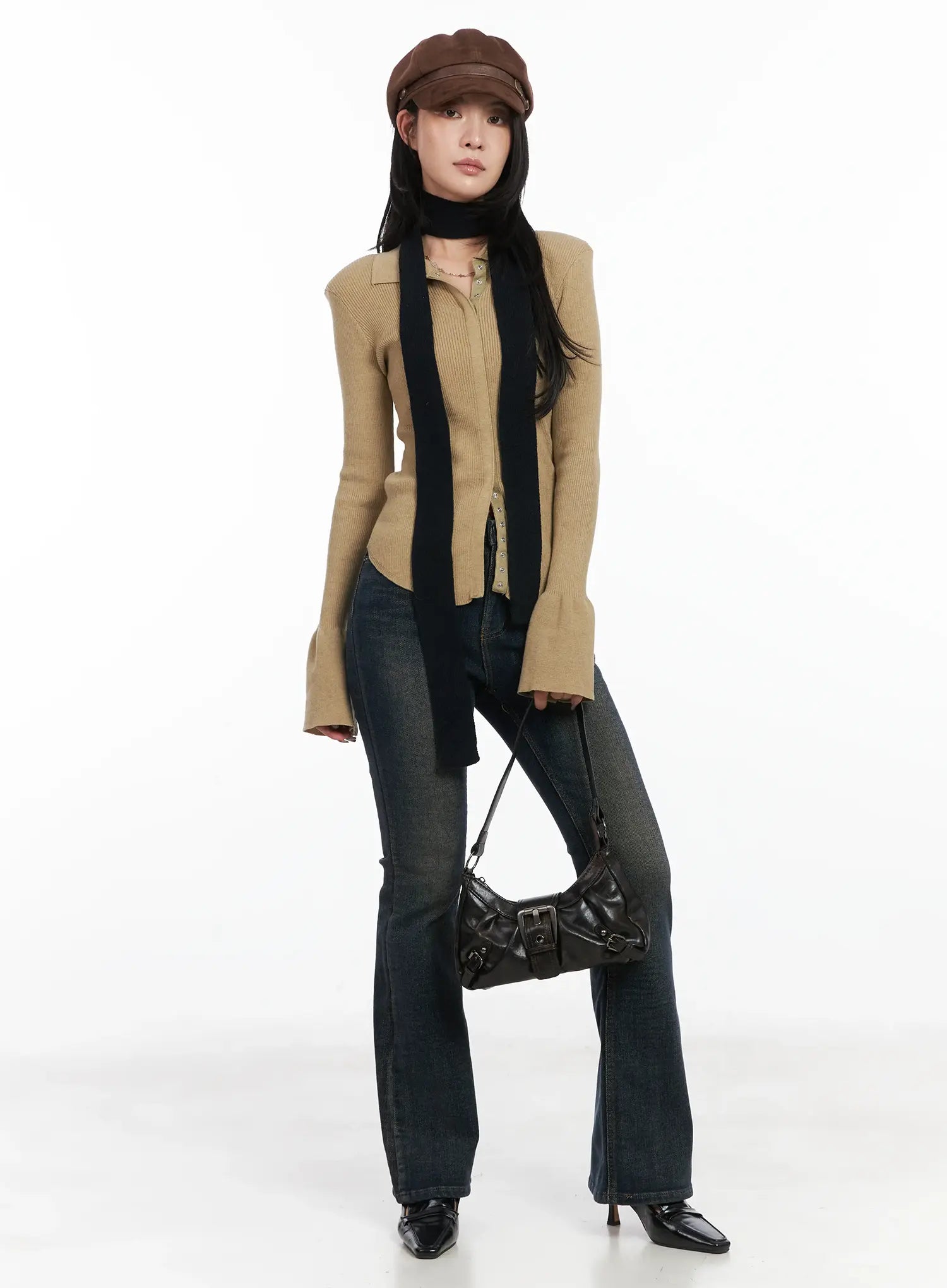 LEWKIN Jordyn High-Waist Bootcut Jeans CD502 in dark washed indigo, full-length front view on model, long bootcut silhouette, styled with camel ribbed cardigan, black scarf, leather baker boy cap, and black shoulder bag.