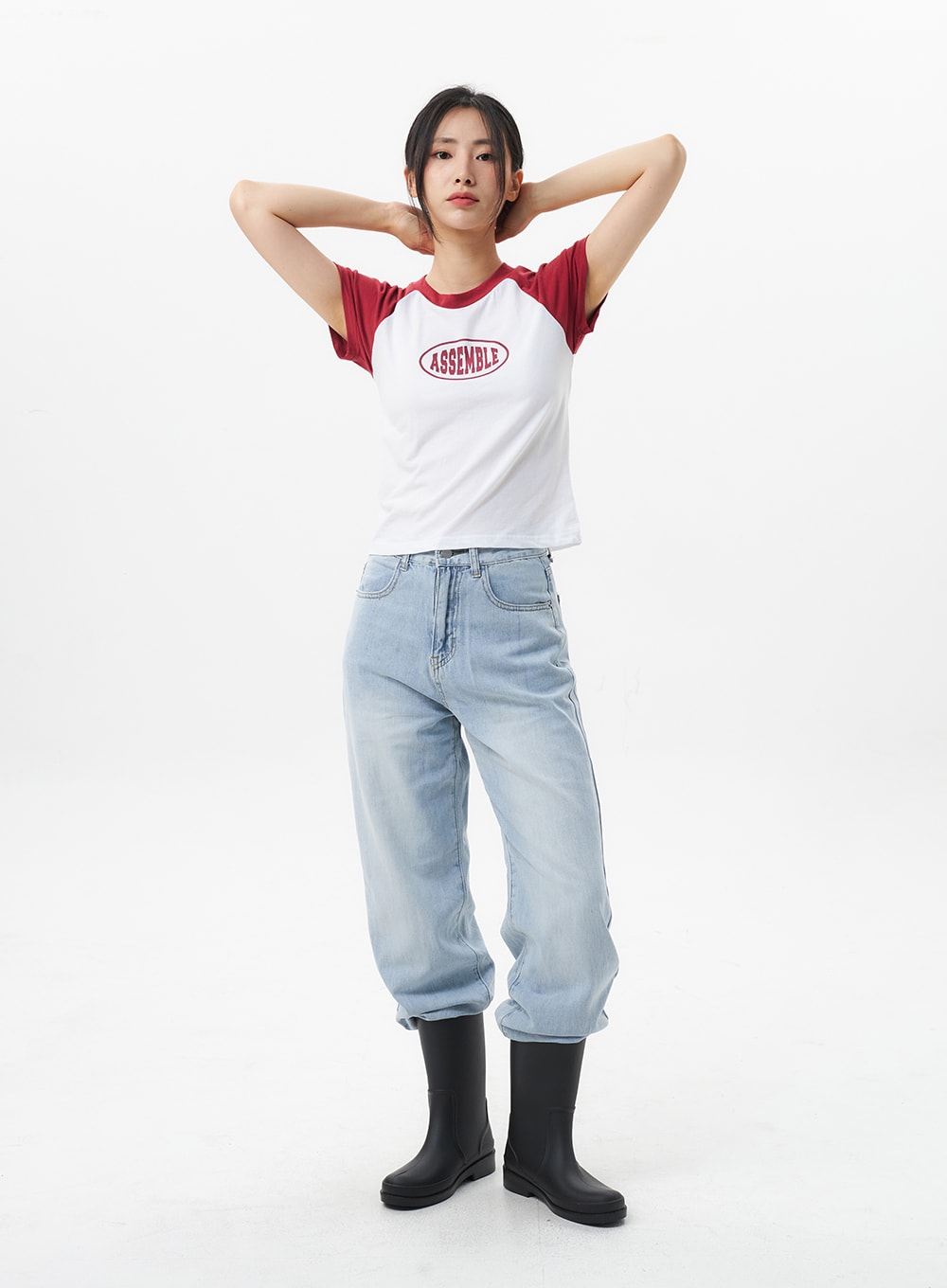 LEWKIN Wide Straight Leg Jeans OL304 in light blue, full-body front shot on model, arms raised behind head, wide-fit cotton denim with faded wash, paired with raglan tee and black rain boots.