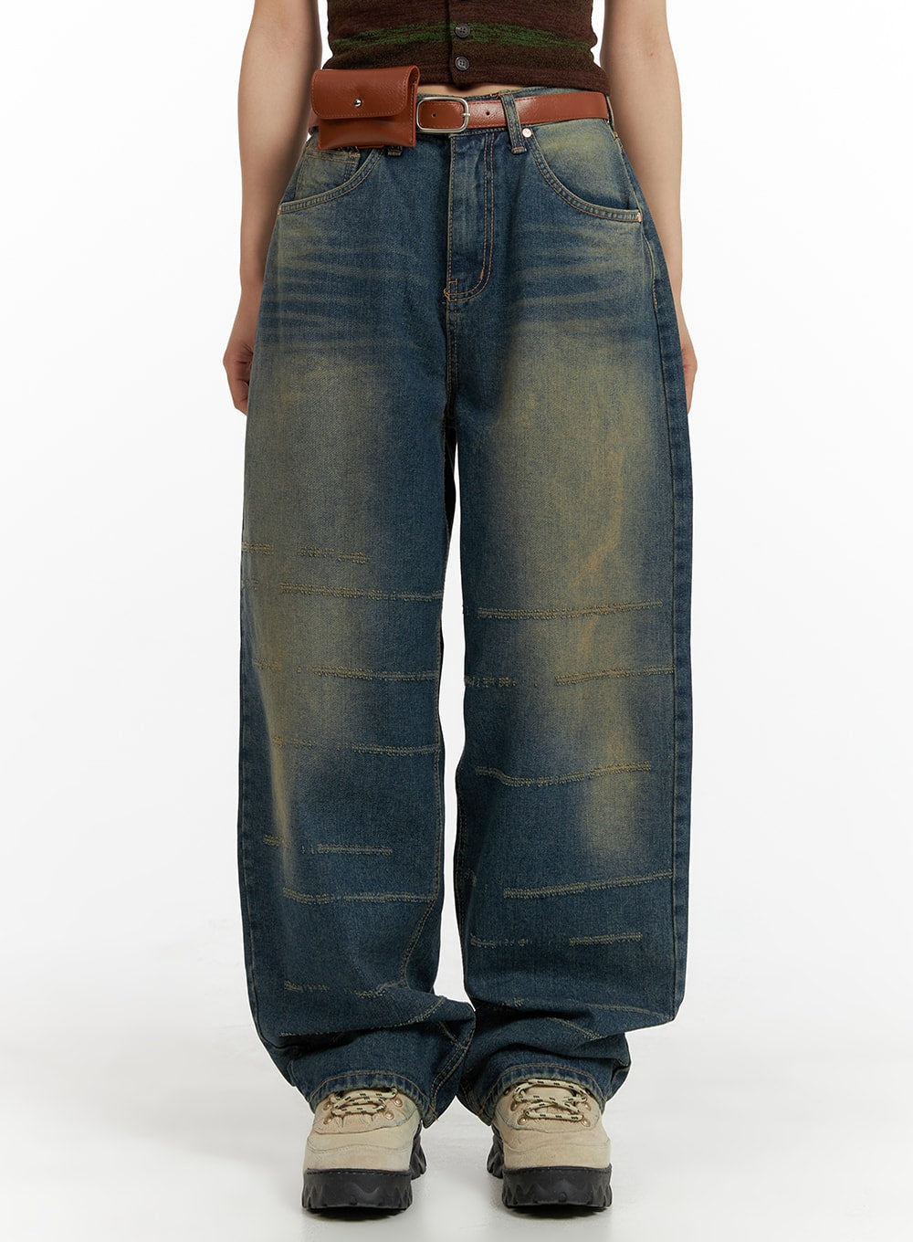 LEWKIN Scratch Textured Baggy Jeans CM405 in washed indigo blue, front half-body shot on model, wide-fit cotton denim with horizontal scratch stitching and yellow-tint fading, styled with brown belt bag and chunky sneakers.