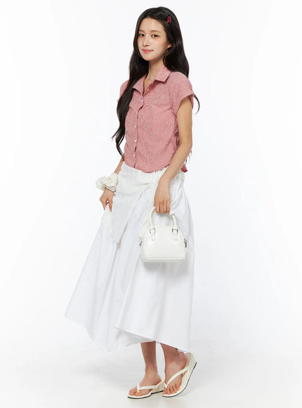 LEWKIN Basic Ribbon Maxi Skirt CU522 in white, 3/4 side full-length shot on model, cotton A-line maxi silhouette with ribbon tie waist, paired with pink textured shirt and white mini bag.