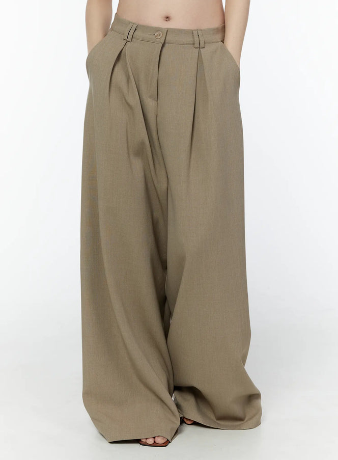 LEWKIN Classic Wide-Fit Pleated Pants IU503 in beige, front cropped view on model, pintuck pleats and belt loops visible, ultra-wide leg silhouette in polyester tailored fabric.