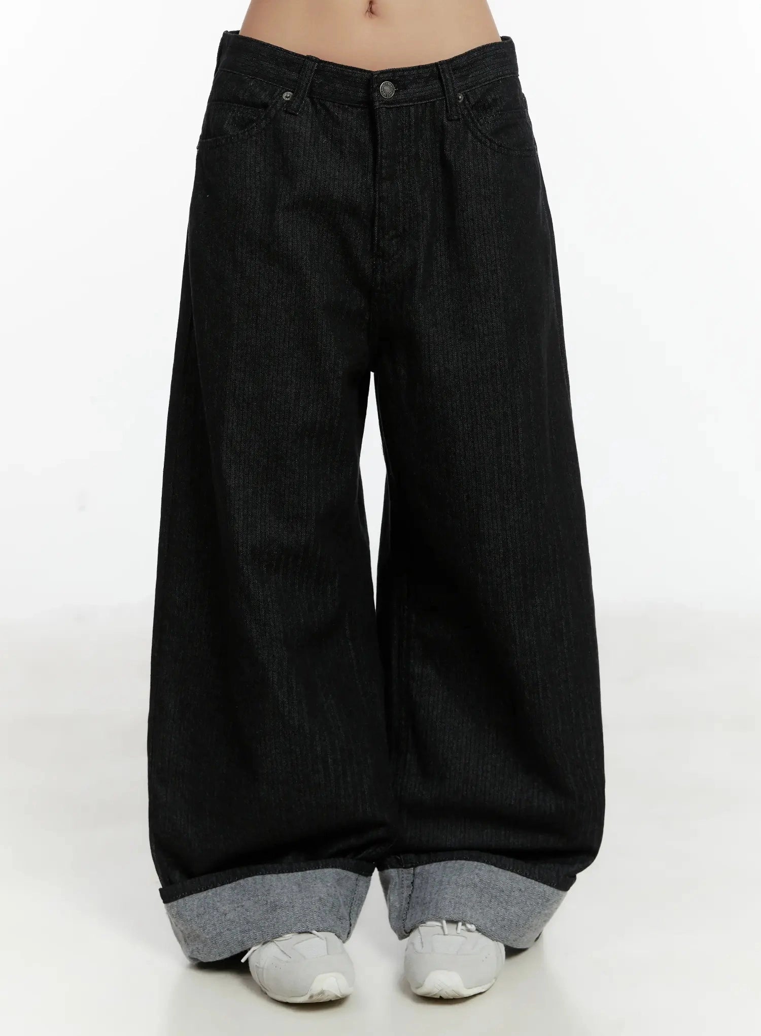 LEWKIN Amyra Baggy Striped Jeans ID525 in black, front view on model, wide-fit cotton denim with low rise, stripe texture, and contrast grey cuffed hem, styled with white sneakers.