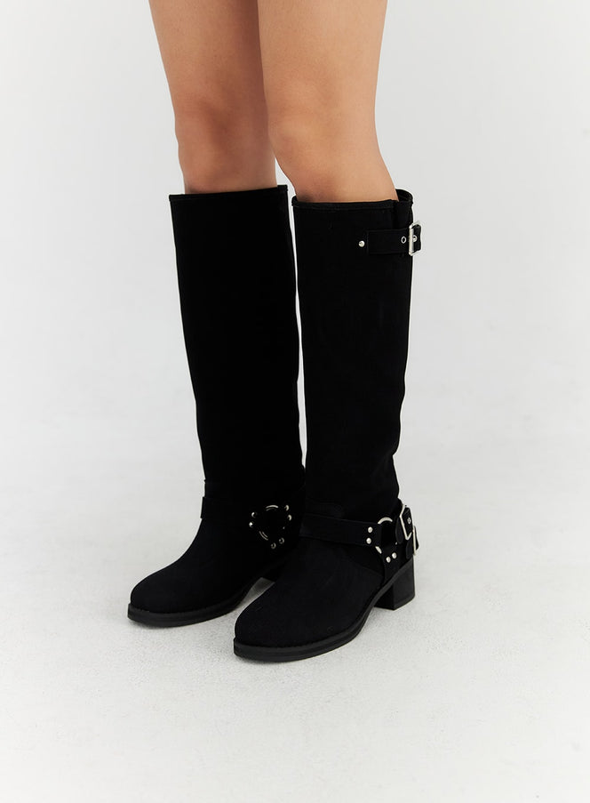 LEWKIN Buckle Faux Leather Boots CN315 in black, front-facing close-up on model, knee-high suede with silver buckle at calf and studded harness strap at ankle, block heel.