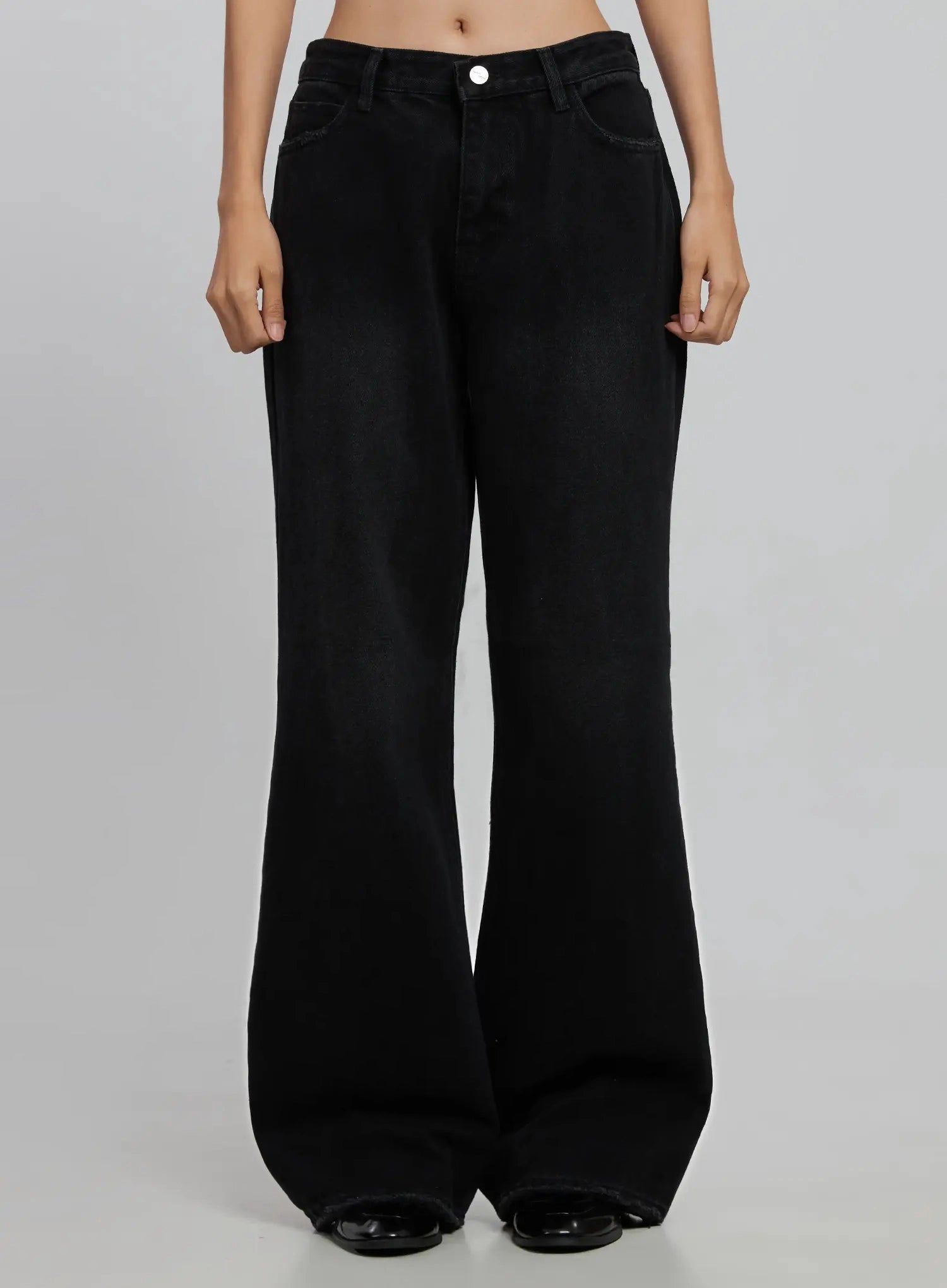LEWKIN Imani Wide-Leg Flared Jeans ID516 in black, front view on model (waist to toe), wide-leg flared cotton denim with silver button, front pockets, long length, worn with black loafers.