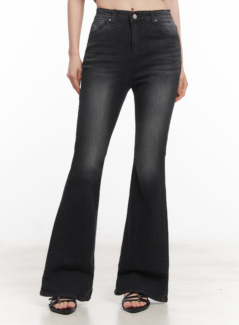 LEWKIN Lior Slim-Fit Bootcut Jeans IY516 in black, front product shot on model, cropped at waist, washed denim slim-to-flare silhouette, high-rise with silver button, paired with black strappy heels.