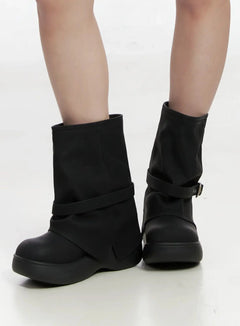 LEWKIN Chunky Platform Mid-Calf Boots IM503 in black, angled close-up on model, faux leather with wrap buckle strap and chunky platform sole, mid-calf height.