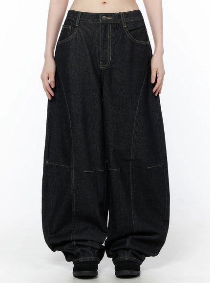 LEWKIN Lova Baggy Jeans CU519 in black, front view on model, ultra-wide leg denim with contrast stitching, curved seam panels, and pooling hem.