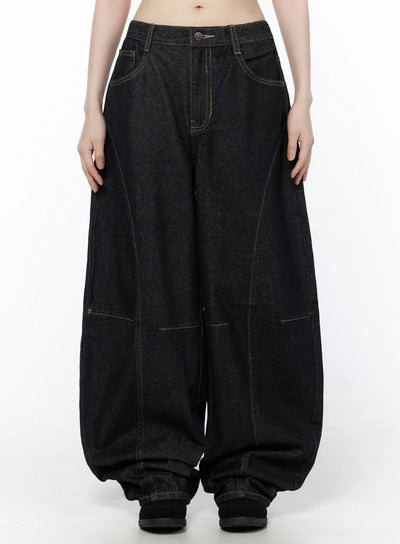 LEWKIN Lova Baggy Jeans CU519 in black, front view on model, ultra-wide leg denim with contrast stitching, curved seam panels, and pooling hem.