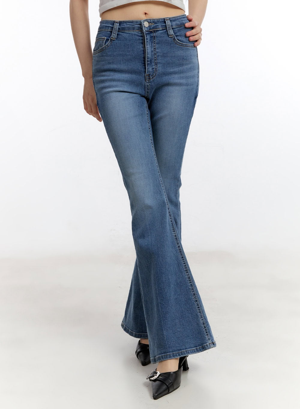 LEWKIN Maris Hip-Pad Bootcut Jeans CA508 in blue, front crop view on model, slim-fit washed denim with high waist, bootcut flare hem, paired with white crop top and black heels.