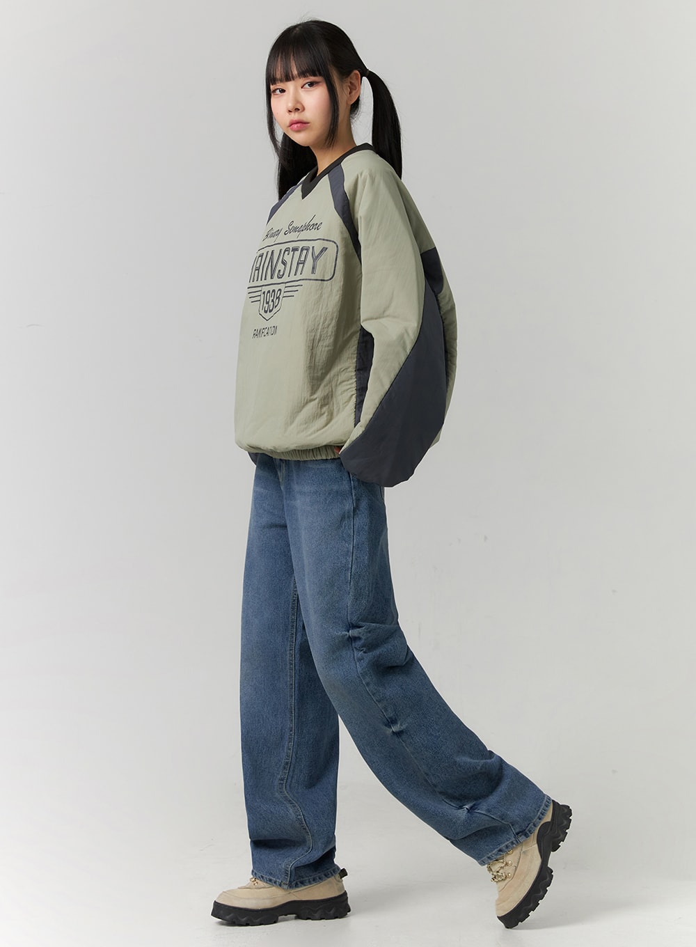 LEWKIN Washed Denim Wide Leg Jeans CD308 in blue, 3/4 side view on model, wide-fit washed cotton denim, regular length, paired with green printed pullover and chunky sneakers.