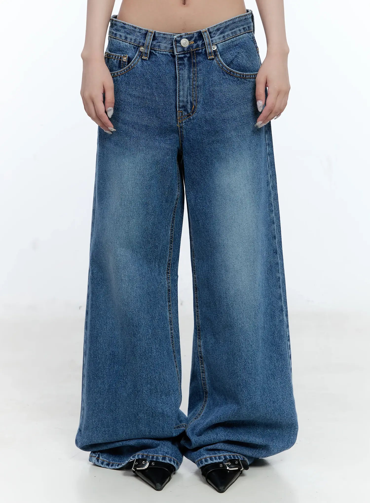 LEWKIN Dahye Washed Relaxed-Fit Denim Jeans CL530 in blue, front crop shot on model, wide-leg cotton denim with washed finish, low rise, button closure, paired with black pointed heels.