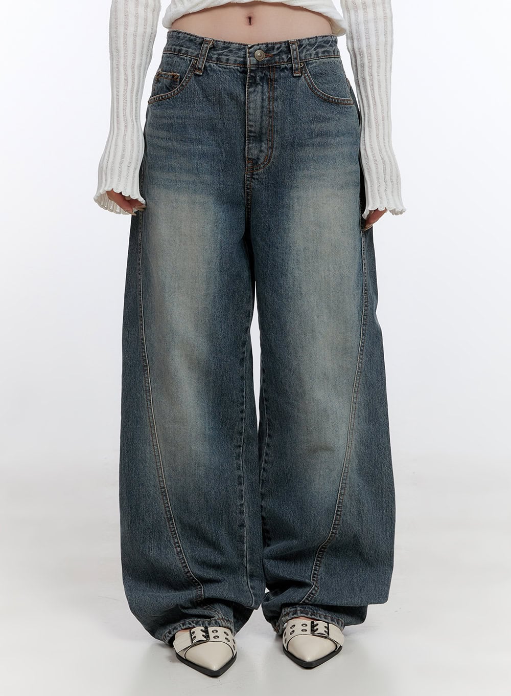 LEWKIN Lucia Stitched Denim Baggy Jeans CO418 in blue, front crop view on model, wide-fit washed cotton denim with curved stitch seam, paired with white ribbed crop top and silver mule heels.