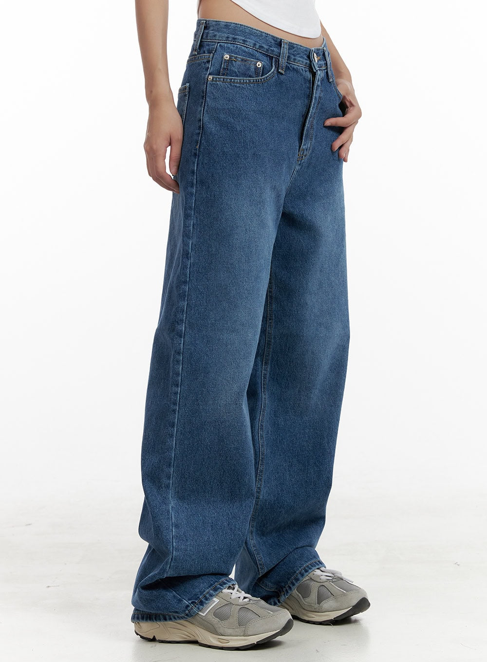 LEWKIN Eva Blue Washed Baggy Jeans CL431 in blue, side close-up on model, wide-fit washed cotton denim, high waist with five-pocket styling, paired with white crop tee and grey sneakers.