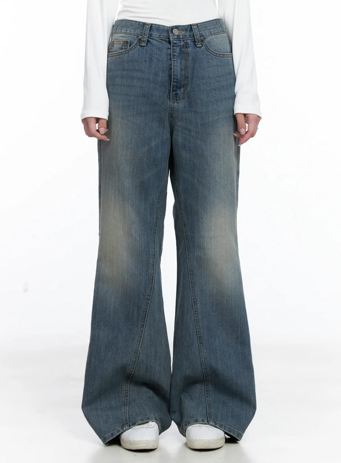 LEWKIN Aylin Wide Bootcut Jeans CS526 in blue, front view on model from waist down, washed cotton denim, wide bootcut silhouette with front stitch seams, paired with white long-sleeve top and white sneakers.