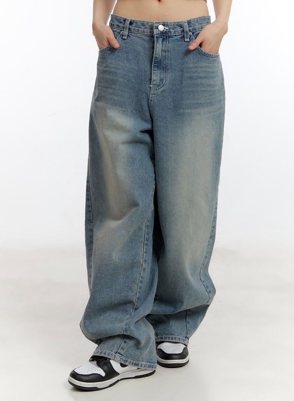LEWKIN Jillie Washed Baggy Jeans CA508 in blue, front crop view on model, wide-fit washed cotton denim with low rise waistband, hands in pockets, paired with chunky sneakers.