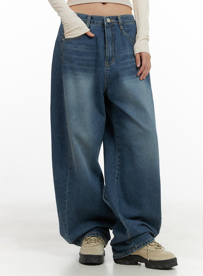 LEWKIN Lacey Washed Denim Baggy Jeans CO404 in blue, front close-up on model, wide-fit washed cotton denim with faded finish, paired with cream long-sleeve top and chunky boots.
