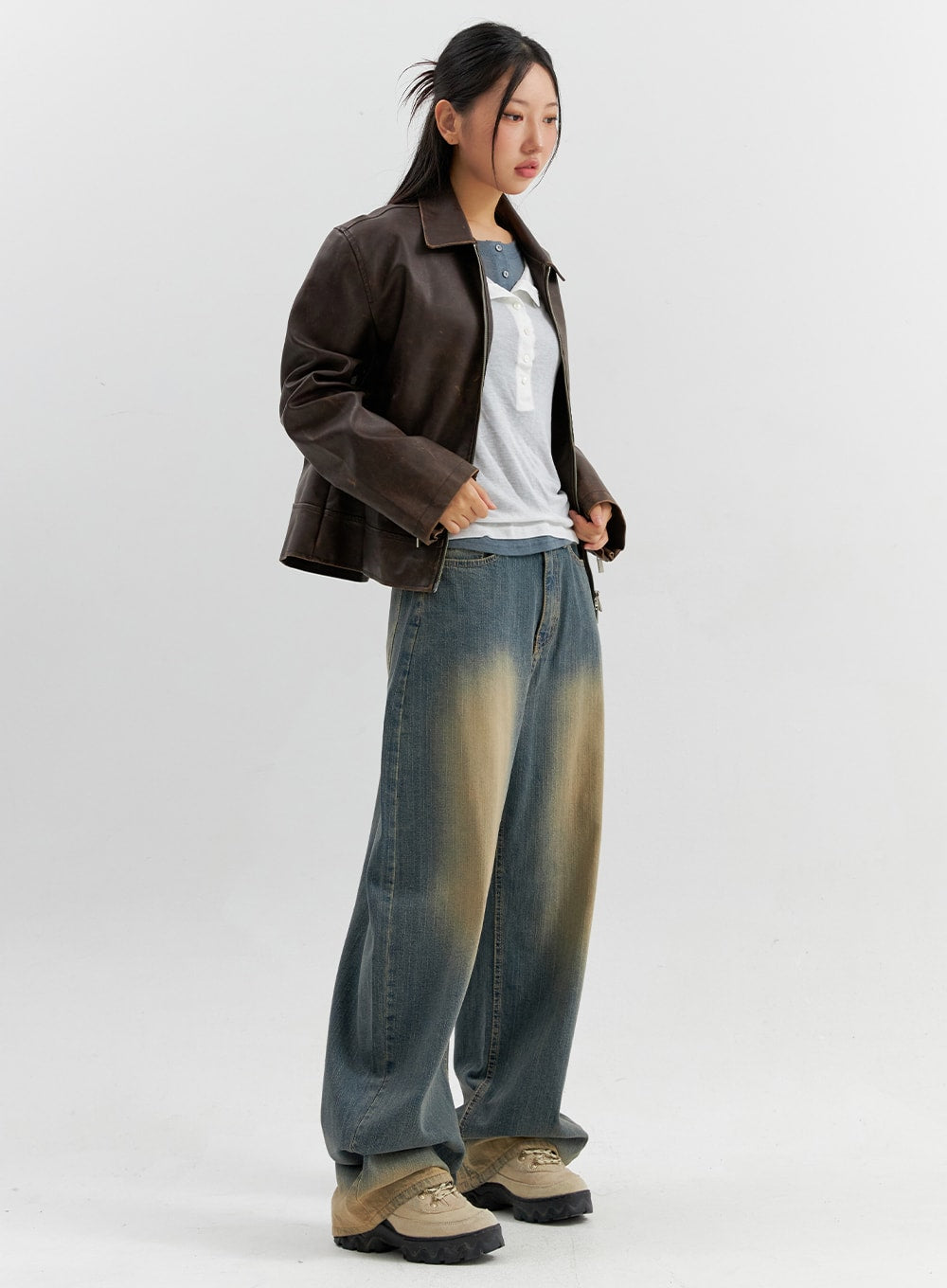 LEWKIN Vintage Wash Wide Leg Jeans CO306 in blue, 3/4 side view on model, vintage-wash cotton denim with yellow-faded thighs, worn with brown leather jacket and white tee.