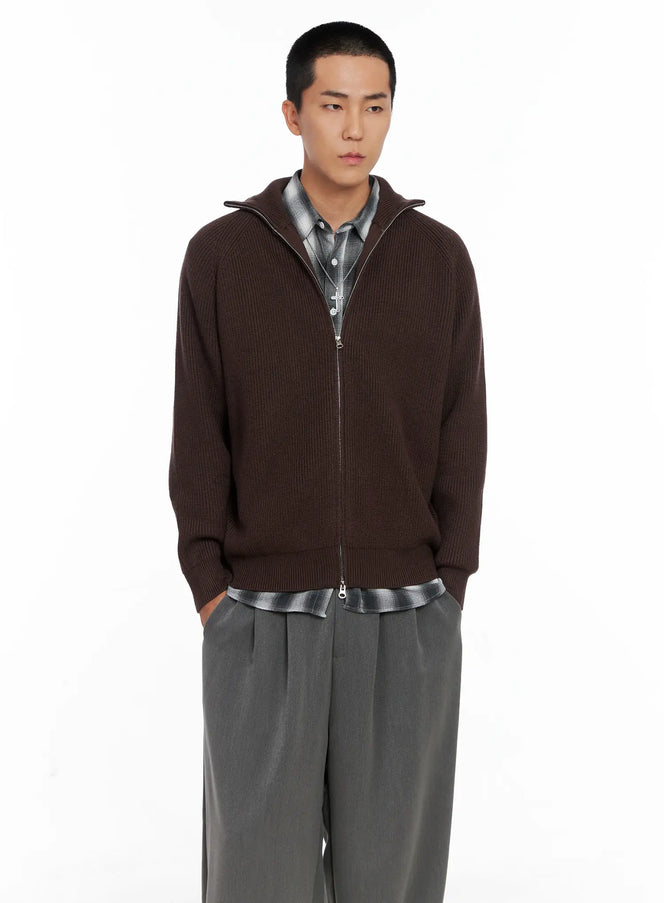 LEWKIN Men's Knit Zip-Up Sweater IS502 in Brown, front close-up on model, ribbed knit with stand collar and full silver zip, layered over grey plaid shirt, paired with wide-leg grey trousers.