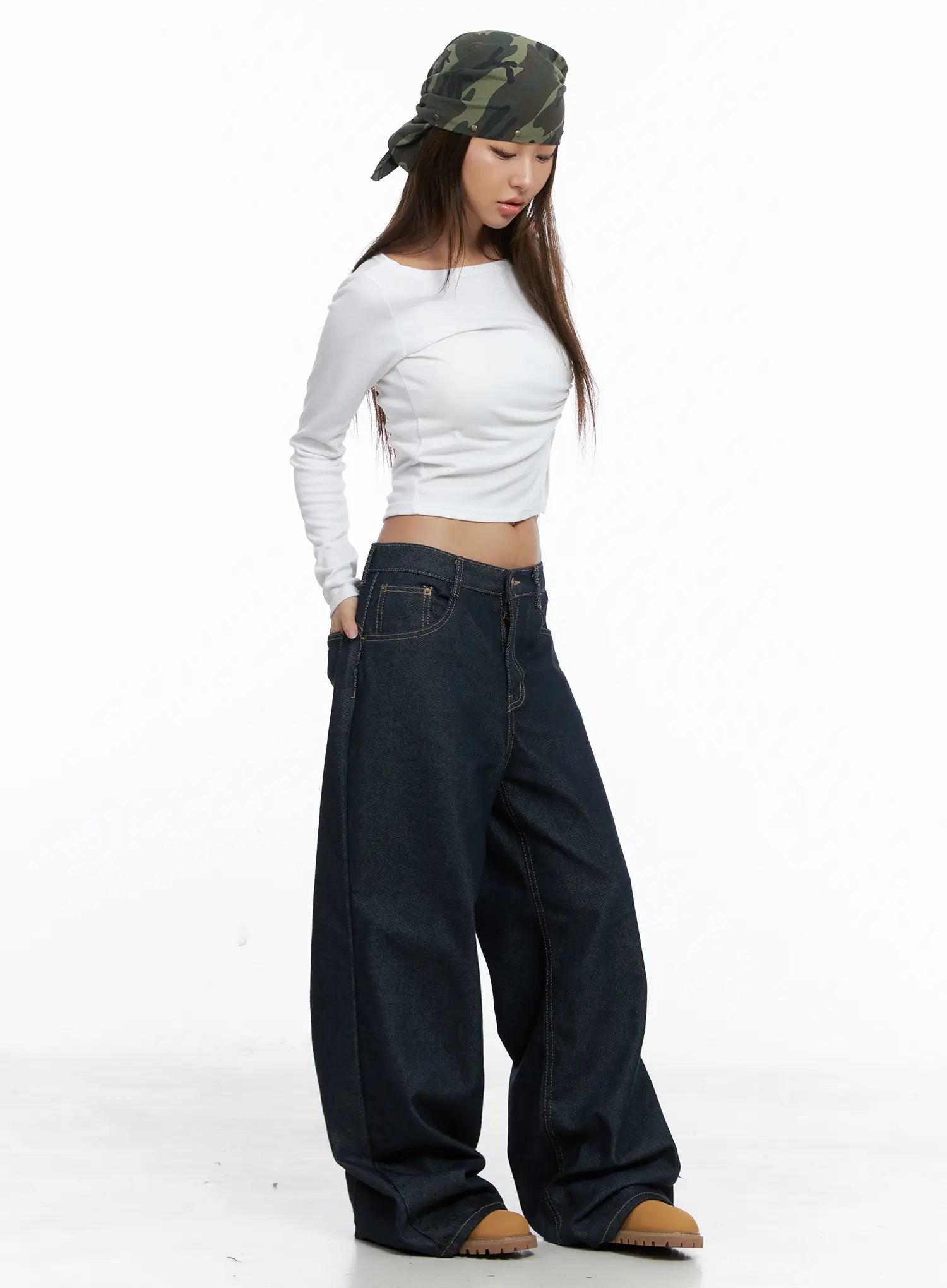 LEWKIN Giada Raw Indigo Wide-Leg Jeans CS505 in dark blue, side full-body shot on model looking down, oversized wide-leg cotton denim pooling at hem, styled with white crop top and camo bandana.