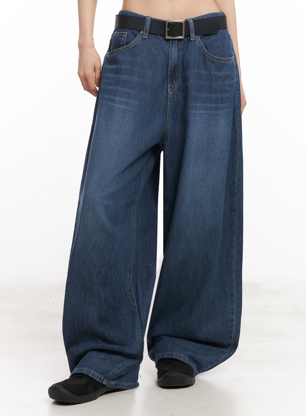 LEWKIN Martha Baggy Jeans IY529 in dark blue, front cropped view on model, ultra-wide washed denim with low rise, styled with black square-buckle belt and black sneakers.