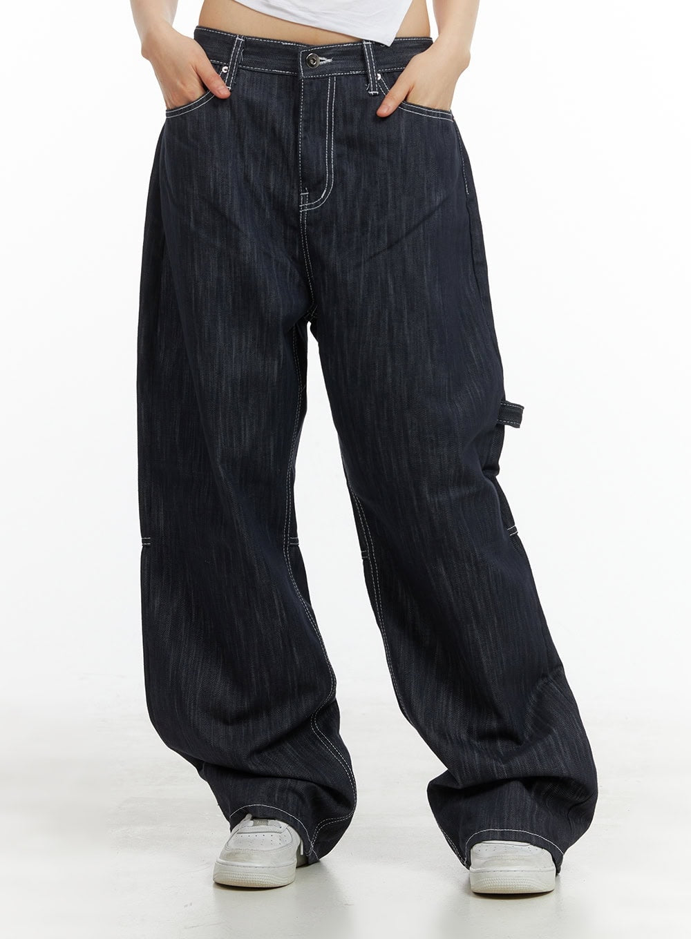LEWKIN Low-Rise Strap Baggy Jeans CY414 in dark blue, front crop shot on model, low-rise wide-leg denim with contrast white stitching and carpenter detail, paired with white sneakers.