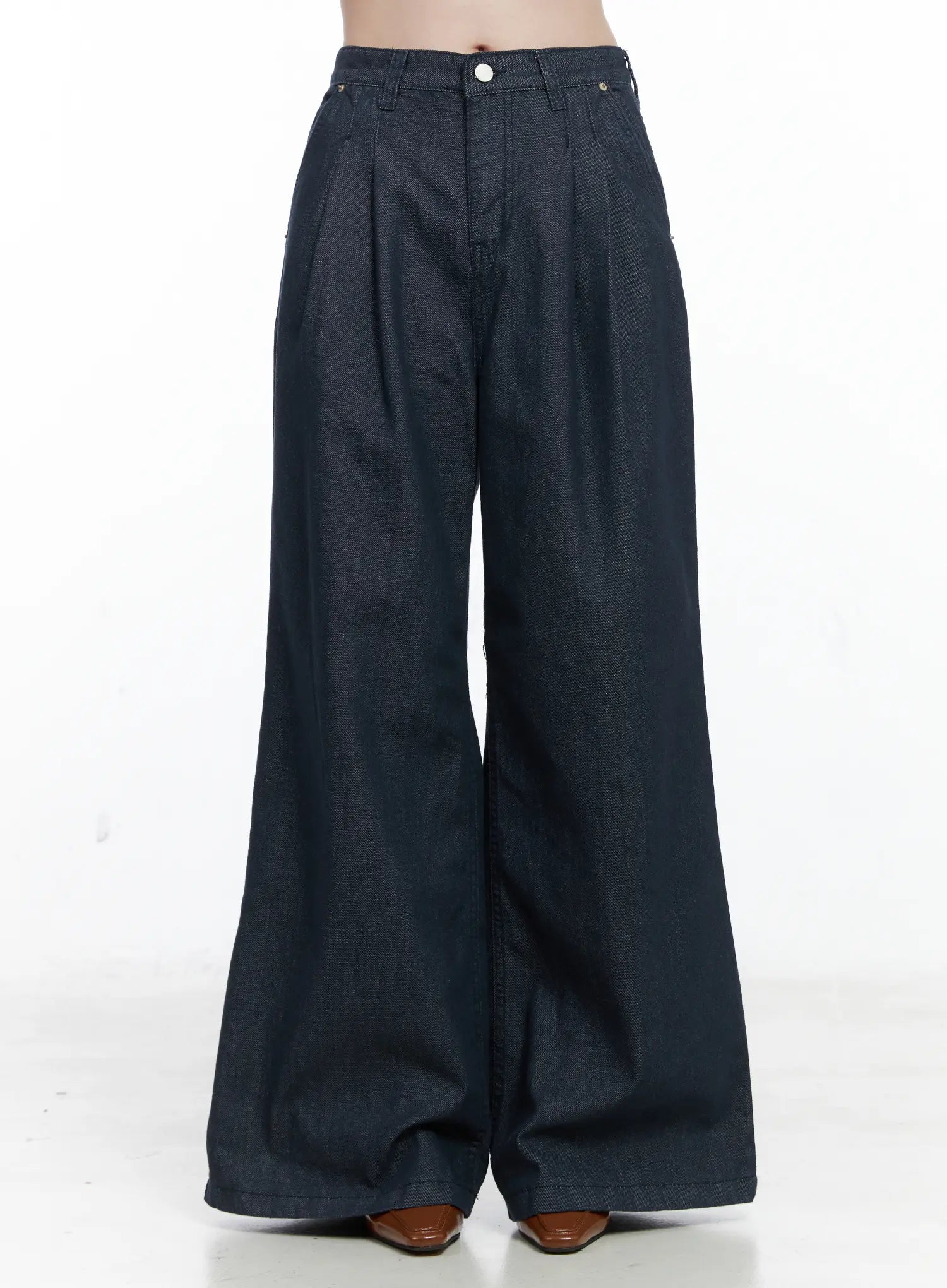 LEWKIN Lena Pintuck Baggy Jeans CO503 in dark blue, front product shot on model (cropped at waist), wide-fit cotton denim with front pintucks, long flared leg, worn with brown heeled boots.