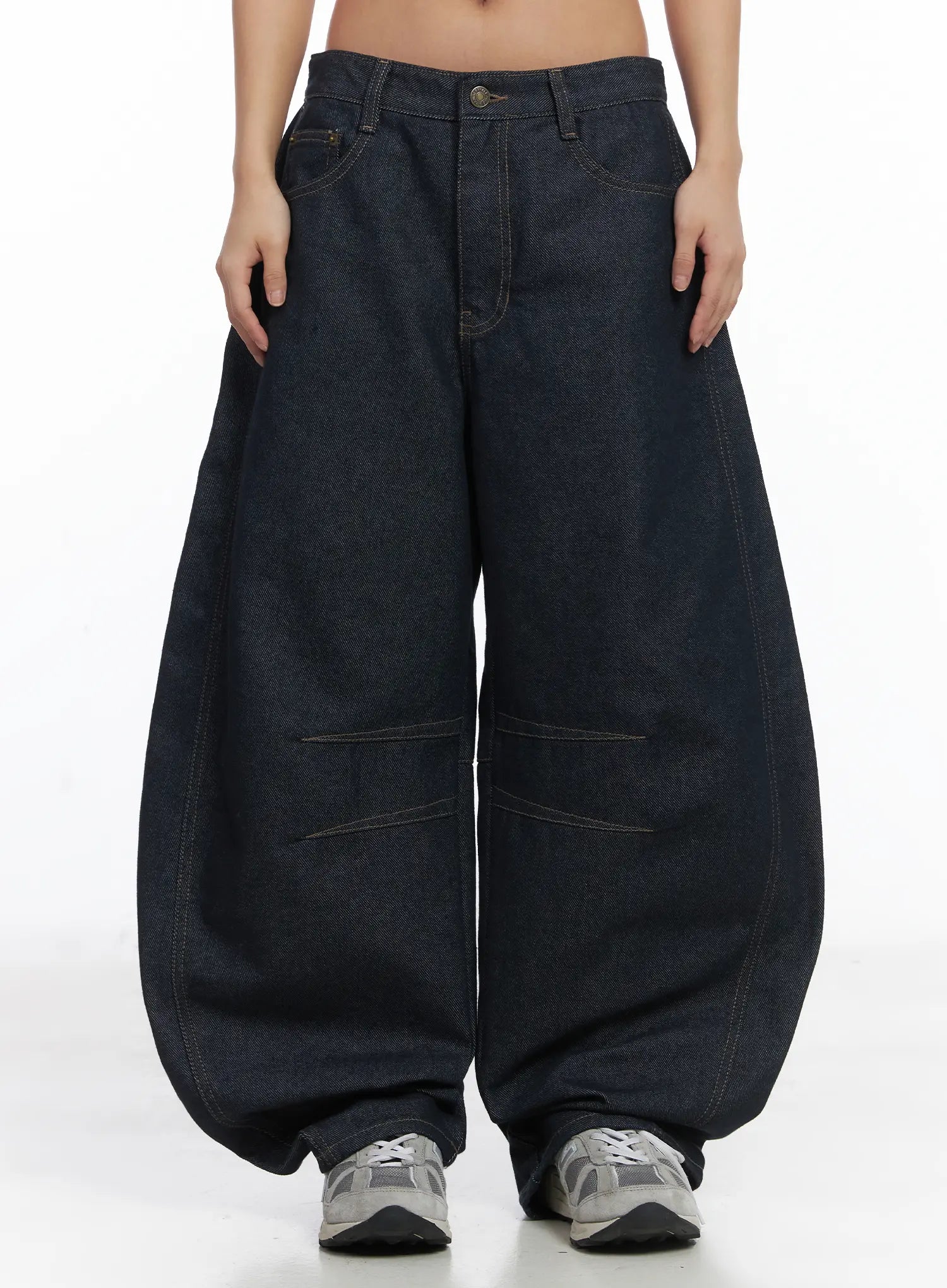 LEWKIN Mingyu Wide Jeans CJ512 in dark blue, front view on model, ultra-wide balloon silhouette with contrast stitching and knee-panel detail, paired with grey sneakers.