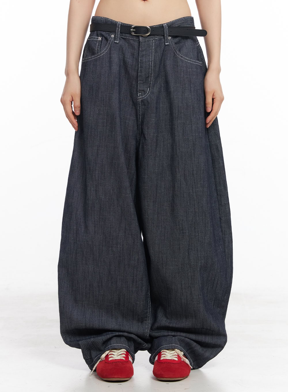 LEWKIN Isabel No-Fade Baggy Jeans CY514 in dark blue, front crop view on model, extreme wide-leg cotton denim with white contrast stitching, belted low waist, pooling hem, styled with red sneakers.