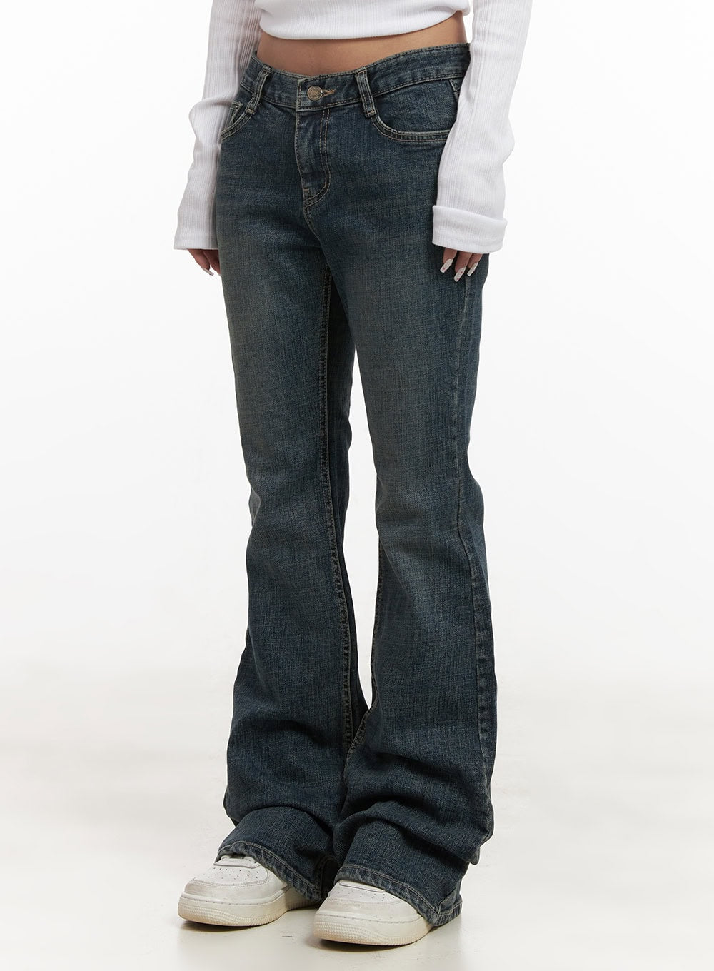 LEWKIN Natalia Low-Rise Flared Jeans CJ508 in dark blue, front close-up on model, washed slim-fit bootcut denim, low waist with button fly, paired with white ribbed long-sleeve top and white sneakers.