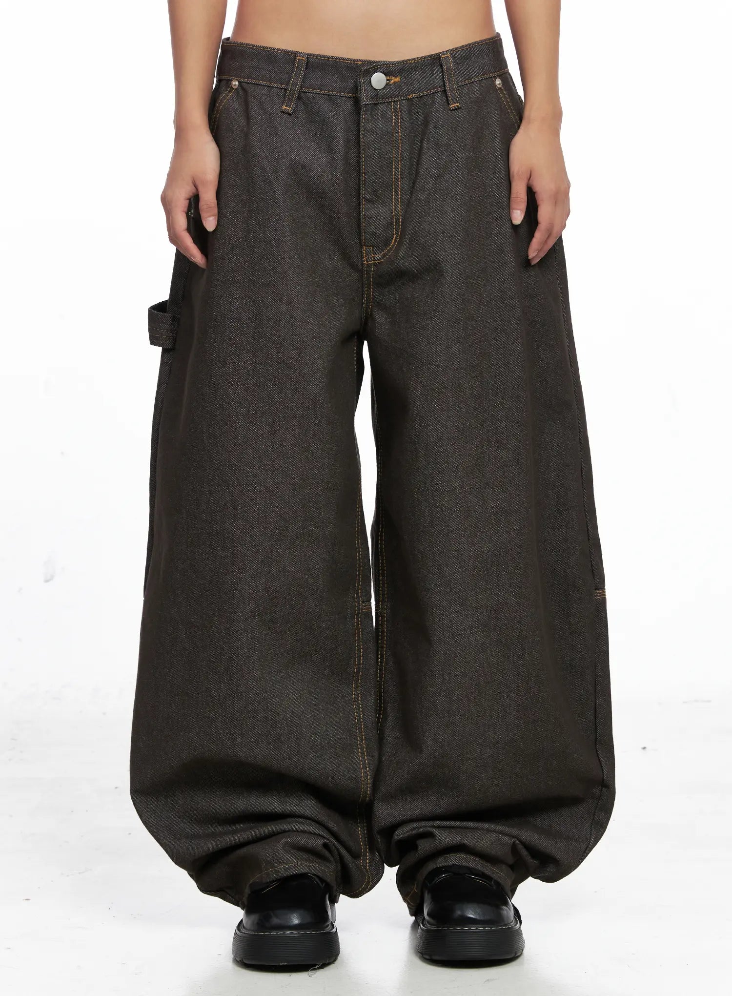 LEWKIN Oaklyn Non-Fade Wide-Leg Jeans CO513 in dark brown, front view on model, low-rise cotton denim with contrast orange stitching, carpenter loop, pooling wide leg hem, paired with black chunky shoes.