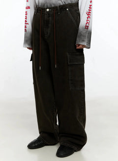 LEWKIN Men's Wide Cargo Jeans IN525 in dark brown, front cropped view on model, wide-leg washed denim with red drawstring, contrast stitching, side cargo pocket, paired with graphic long sleeve.