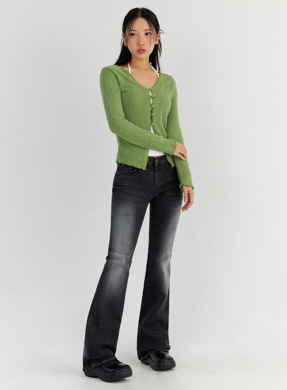 LEWKIN Bootcut Washed Jeans CO325 in dark gray, full-body front-angled view on model, slim bootcut silhouette in washed cotton denim, paired with green bouclé cardigan and black platform shoes.