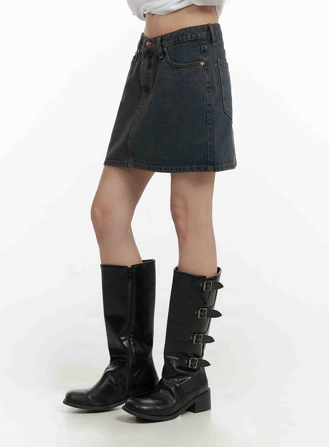 LEWKIN Low Wash Indigo Dream Denim Mini Skirt CY407 in dark gray, side view on model, low-waist washed cotton denim, front pockets visible, paired with black buckle knee-high boots.