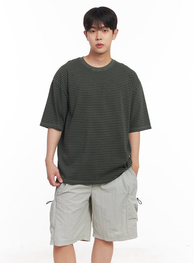 LEWKIN Men's Cotton Striped Round-Neck T-Shirt IY522 in dark green, front half-body on model, oversized fit with thin black horizontal stripes, paired with light grey cargo shorts.