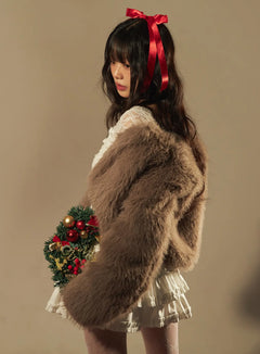 LEWKIN Cropped Faux Fur Jacket CN520 in dark pink, side editorial shot on model holding Christmas wreath, fluffy long sleeve collarless cropped silhouette, styled with white lace top and ruffled mini skirt.