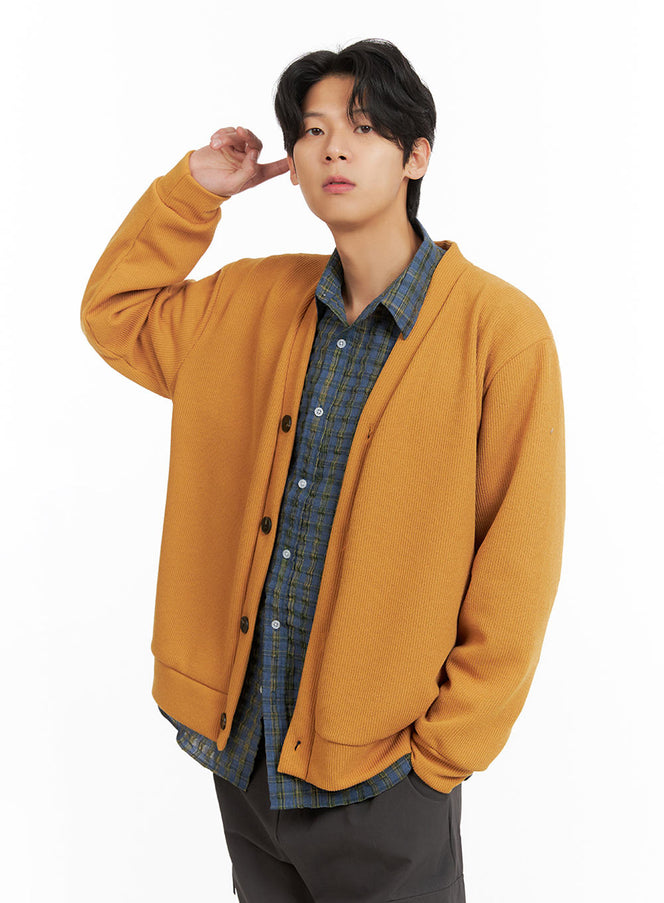LEWKIN Men's V-Neck Buttoned Sweater IA402 in dark yellow, angled front close-up on model, ribbed knit with dark buttons, layered over blue plaid shirt, one hand raised.