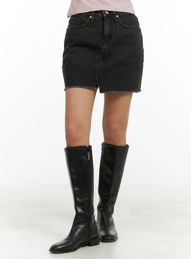 LEWKIN Front Slit Denim Mini Skirt CA415 in gray, angled front view on model, slim-fit washed cotton denim with frayed hem, paired with black knee-high leather boots.