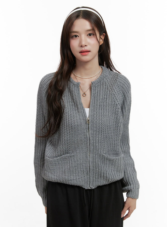 LEWKIN Warm Knit Zip-Up Cardigan OS416 in gray, front view on model, chunky acrylic knit with zip closure, front pockets, paired with black trousers.