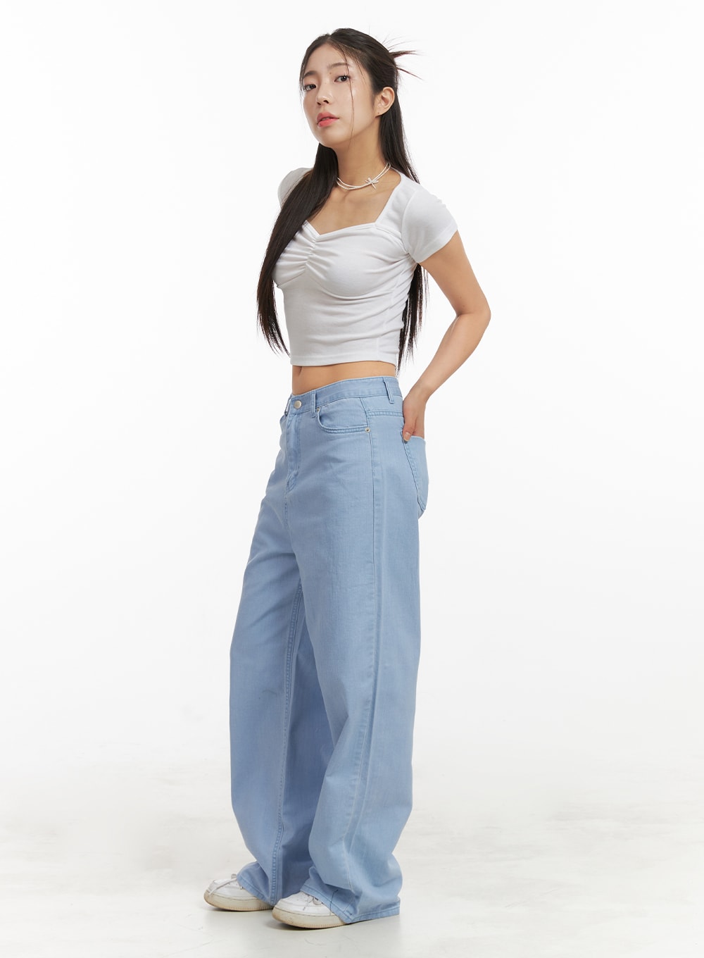 LEWKIN Solid Cotton Loose Fit Straight Jeans OA429 in light blue, 3/4 side view on model, wide-leg straight silhouette with low rise, paired with white crop top and sneakers.