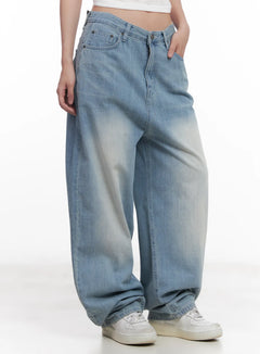 LEWKIN Hani Light-Wash Wide-Leg Jeans CU517 in light blue, front three-quarter close-up on model, oversized cotton denim with washed fading, low-rise waist, paired with white sneakers.